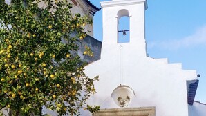 Una chiesa bianca con un campanile e un'ampia porta in legno.