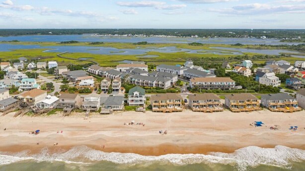 A coastal residential area with beachfront properties, a sandy beach, and a marshy landscape in the background. - Oceanview Townhouse w/ Pool - Newly Renovated (Surf City)