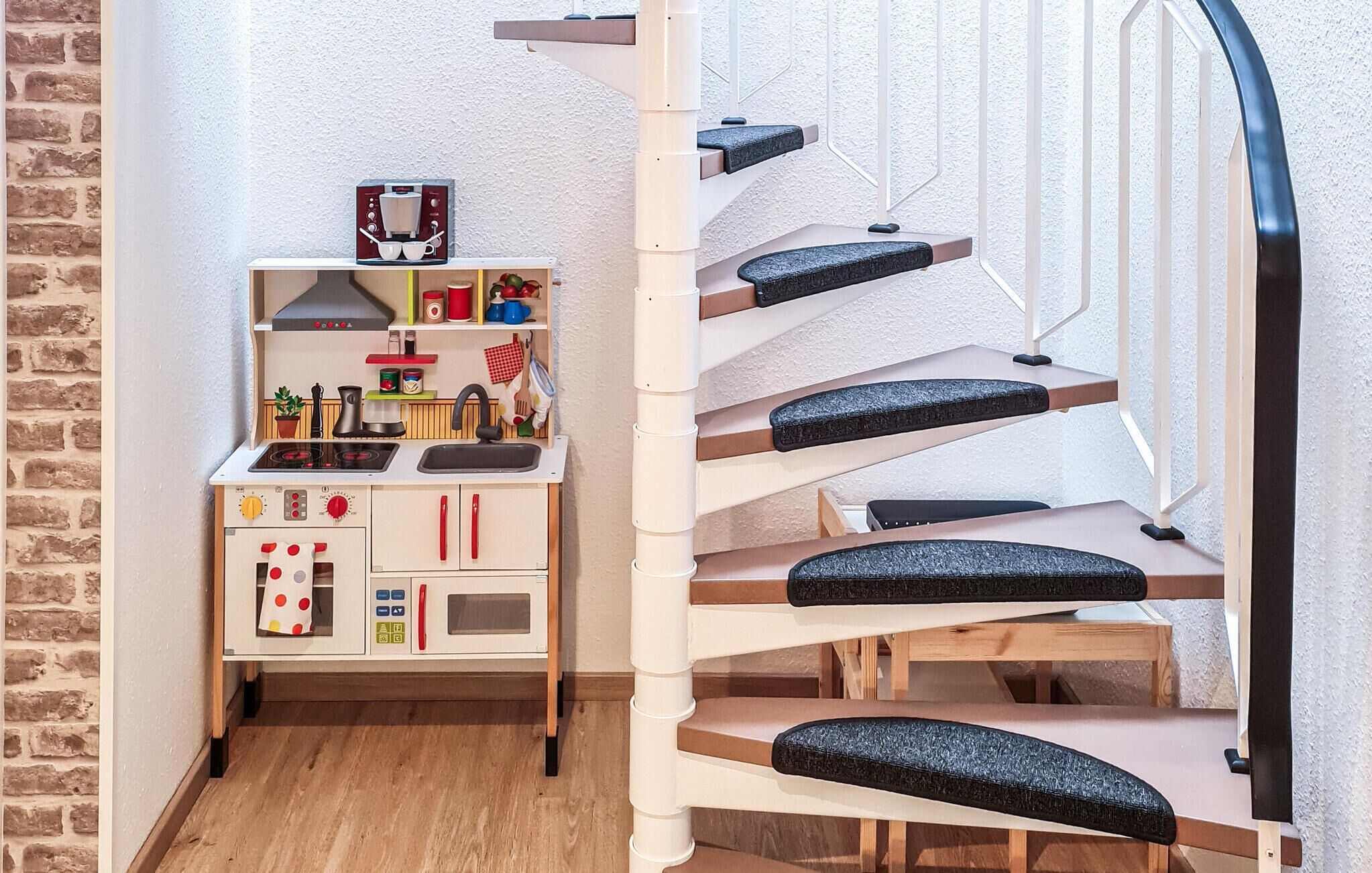 Una cocina de juguete para niños con una escalera en espiral.