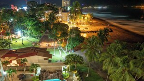 Un complexe hôtelier doté de plusieurs piscines, de palmiers et offrant une vue sur la plage.