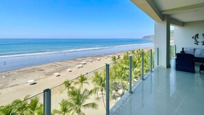 Un balcon avec vue sur une plage et l’océan.