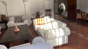 A spacious living area with a white sofa, a wooden coffee table, and a decorative vase.