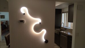 Uma cozinha moderna com máquina de lavar louça embutida e luminária de parede curva.