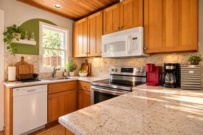 A kitchen with wooden cabinets, a stainless steel stove, a microwave, and a coffee maker.