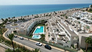 Un hôtel en bord de mer doté d’une piscine, de plusieurs balcons et offrant une vue sur la plage et l’océan.