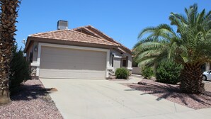 A residential house with a garage, a driveway, and palm trees. - Private Heated Pool in Apache Junction (Apache Junction)