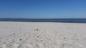 A sandy beach with a clear blue sky and calm sea. - New, exclusive vacation home close to the beach with sauna, 3 bedrooms, fireplace, garage, (Dranske-Lancken)