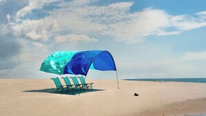 A beach with a blue tent and a lounge chair. - Shimmering Tides~Golf Cart~Secluded (Port St. Joe)