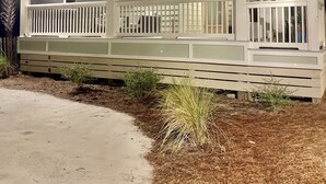 A two-story house with a covered porch and a single-story extension. - Shimmering Tides~Golf Cart~Secluded (Port St. Joe)