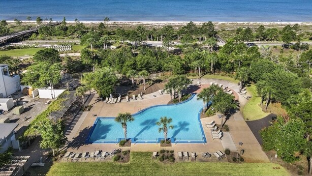 A resort with a large pool, palm trees, and a beach view. - Shimmering Tides~Golf Cart~Secluded (Port St. Joe)