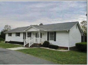 Stroll up to the charming front porch, accessible via a small set of stairs, and enter through the central entrance.