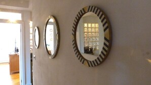Tres espejos adosados a la pared con marcos decorativos en un pasillo.