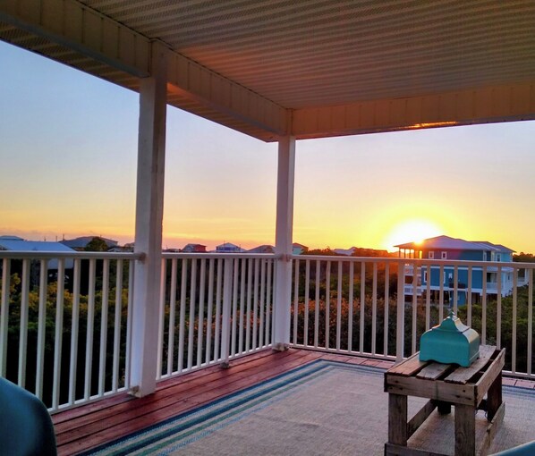 A covered porch with a view of houses and a sunset. - WALK TO PRIVATE ACCESS "PET FRIENDLY BEACH" ENJOY
PRIVATE POOL & HOT TUB (Gulf Shores)