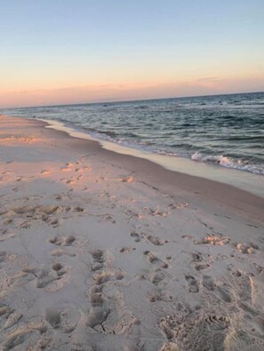 A beach with footprints in the sand and a calm sea. - WALK TO PRIVATE ACCESS "PET FRIENDLY BEACH" ENJOY
PRIVATE POOL & HOT TUB (Gulf Shores)