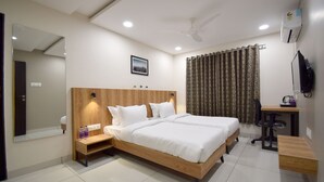 Un dormitorio con una cama de madera, un escritorio, una silla, un espejo y un ventilador de techo.