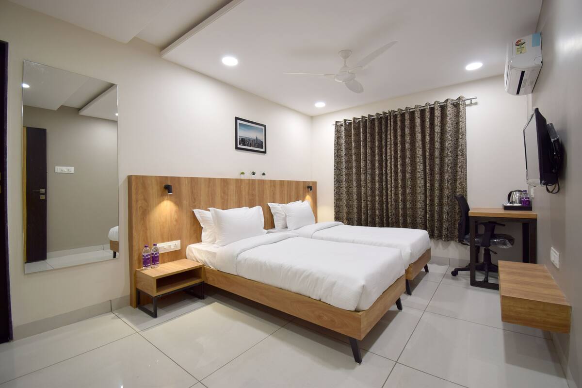 A bedroom with a wooden bed, a desk, a chair, a mirror, and a ceiling fan.