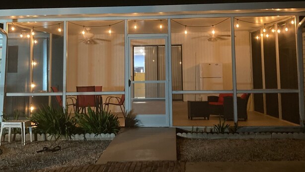 A modern house with a glass door leading to a patio area.