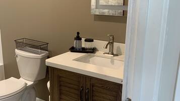 A bathroom with a toilet, sink, and cabinet.