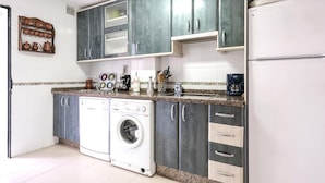 A compact kitchen with a washing machine, a coffee maker, and a toaster. - 3 bedroom awesome home in Matalascañas (Matalascañas)