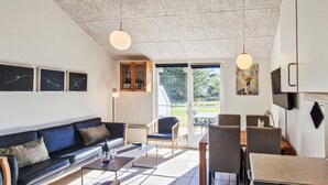 Ein modernes Wohnzimmer mit Sofa, Couchtisch und Essbereich.