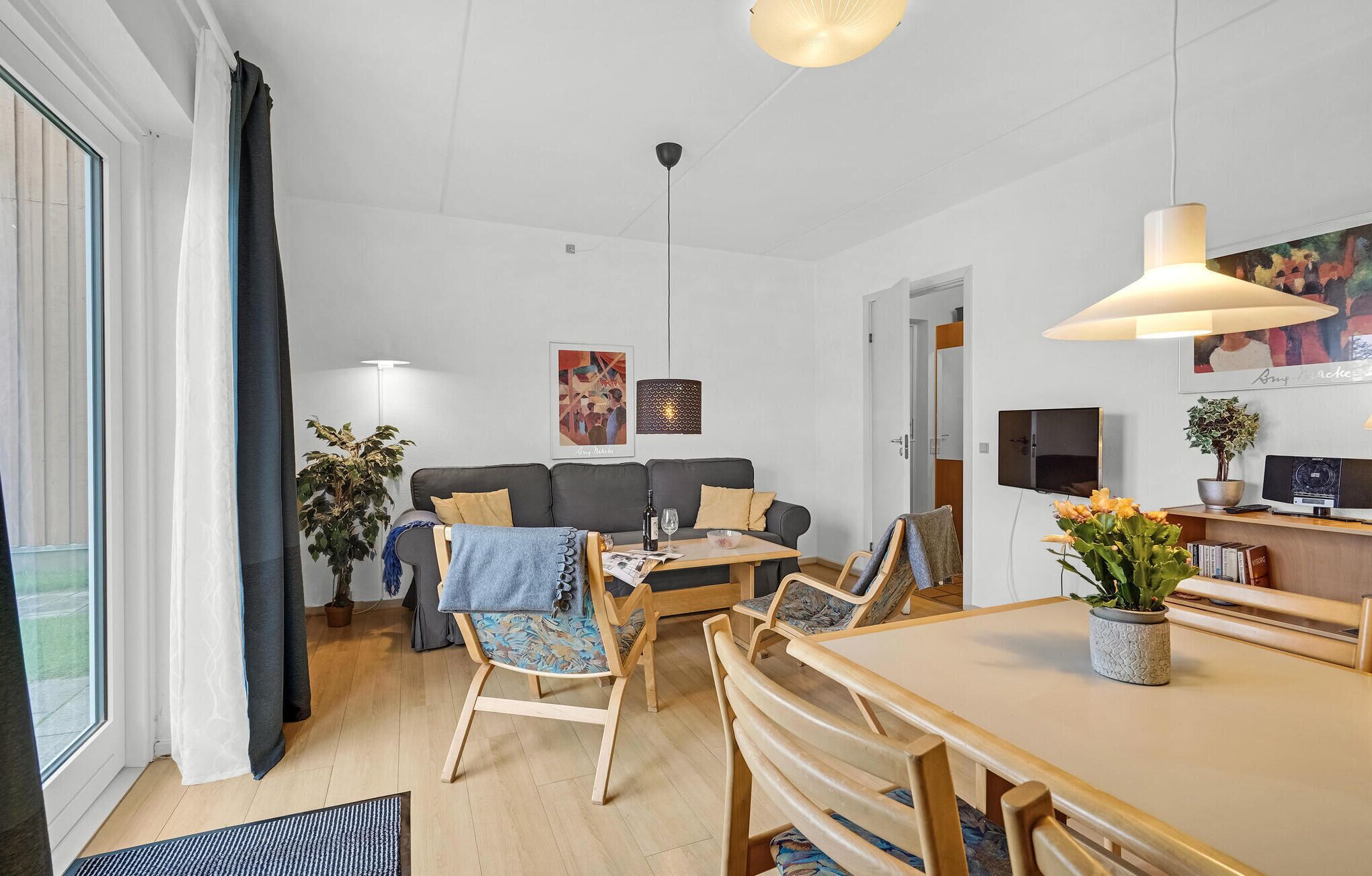 Un salon moderne comprenant un canapé, une table à manger, des chaises et un téléviseur.