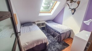 A small, compact room with two beds, a skylight, a wooden desk, and a mounted deer head. - 2 bedroom cozy home in Rydsgård (Rydsgård)