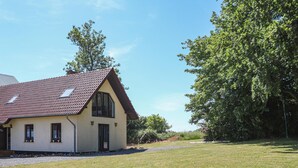 A single-story house with a sloped roof, a small porch, and a gravel driveway. - 2 bedroom cozy home in Rydsgård (Rydsgård)