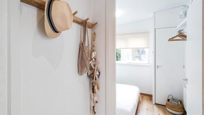 A hallway with a hat rack, a door leading to a bedroom, and a window with blinds. - Lovely home in Heinkenszand with WiFi (Heinkenszand)