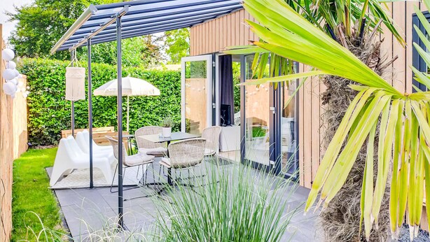 A patio with outdoor furniture, a covered seating area, and a view of the garden. - Lovely home in Heinkenszand with WiFi (Heinkenszand)