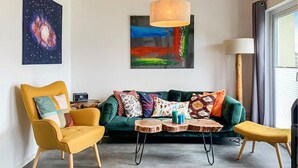 Una sala de estar moderna con un sofá verde, sillones amarillos y una mesita de centro pequeña.