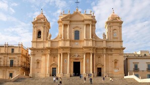 A grand historical building with a central entrance, two towers, and a bell tower. - 3 bedroom beach front home in Siracusa (Siracusa)