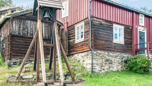 Un edificio rústico de madera con una torre de campanas y cimientos de piedra.