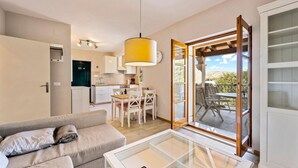 A compact living space with a kitchenette, a dining area, and a glass-enclosed balcony. - Cozy apartment in Zaboric with kitchen (Zaboric)
