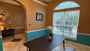 A dining area with a dark wooden table, bench, and chandelier. - Minutes from Destin Beaches (Fort Walton Beach)