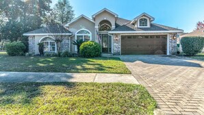 A two-story house with a garage, a front porch, and a well-maintained lawn. - Minutes from Destin Beaches (Fort Walton Beach)