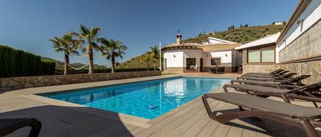Una piscina al aire libre, tumbonas