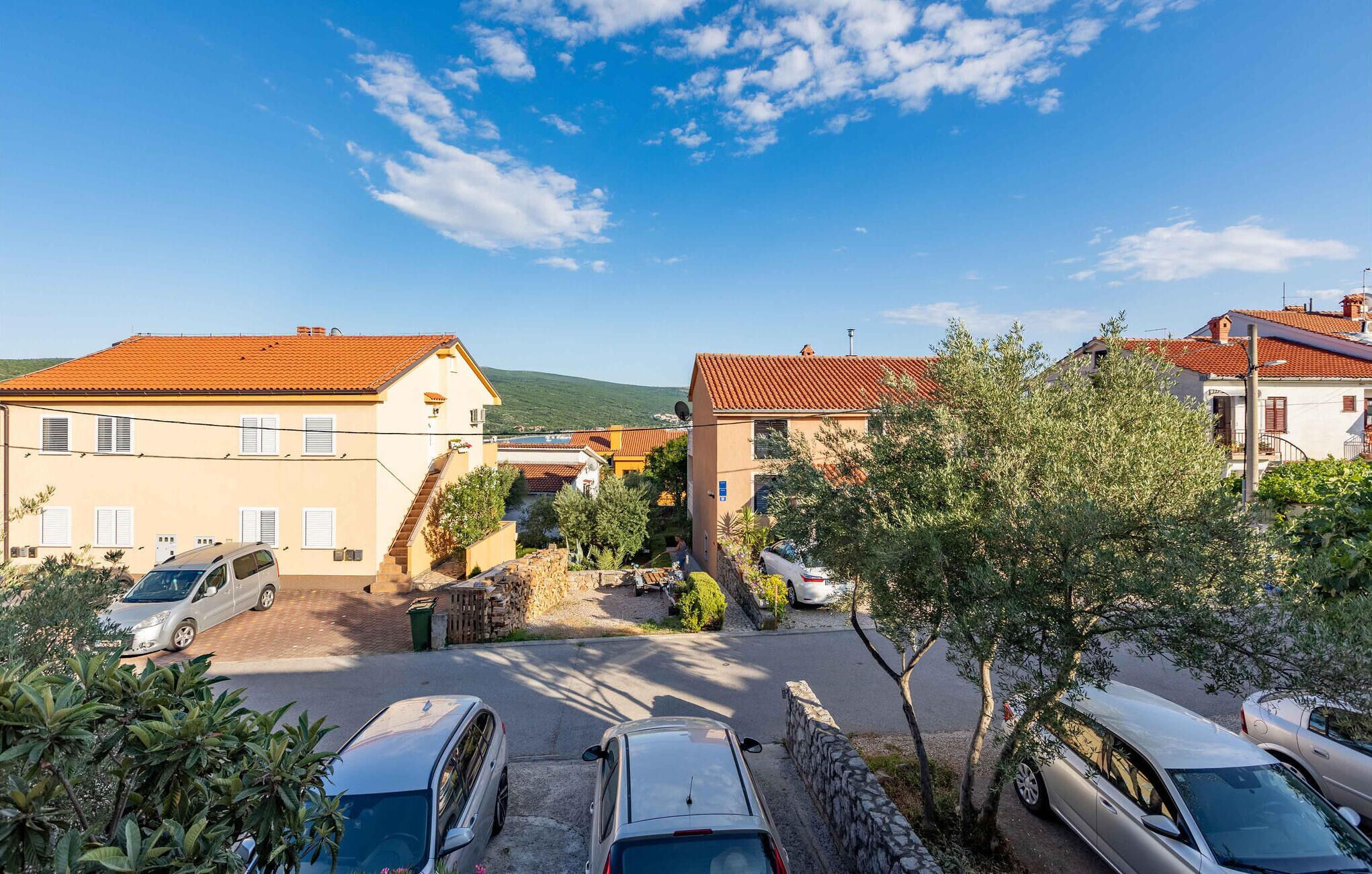 Zona residencial con casas, coches aparcados y cielo despejado.
