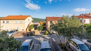 Un quartier résidentiel avec des maisons, des voitures garées et un ciel dégagé.
