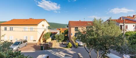 Zona residencial con casas, coches aparcados y cielo despejado.