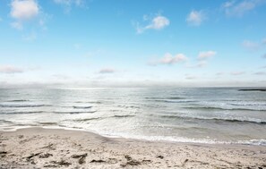En strand med klar himmel och milda vågor.