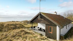 A coastal building with a sloped roof, a satellite dish, and a sign reading "Pulsatilla". - Beautiful home in Aakirkeby with WiFi (Aakirkeby)