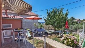 A patio with outdoor furniture, a table, and a red umbrella. - 1 bedroom beautiful home in Pula (Pula)