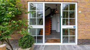 Un bâtiment à la façade en briques, une enseigne indiquant « Thuja », et un escalier menant à l’intérieur.