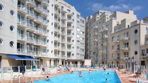 A swimming pool surrounded by multi-story residential buildings with balconies. - Pet friendly apartment in Oostende (Oostende)