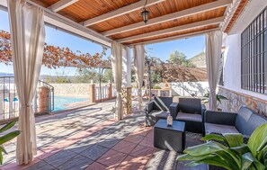 A covered patio area with outdoor furniture, a pool, and a stone wall. - Lovely home in Padul with private swimming pool, can be inside or outside (Padul)
