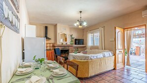 Une cuisine chaleureuse avec un coin repas, une cheminée et un téléviseur.