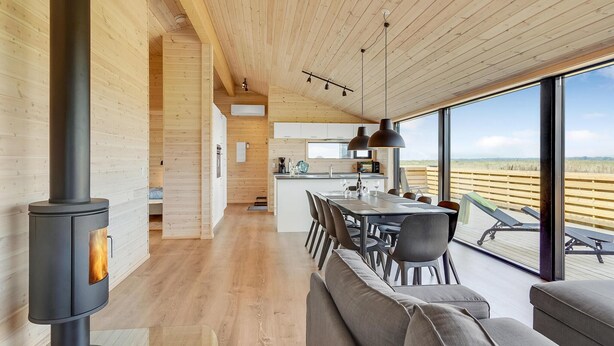 A modern interior with a wood stove, a dining area with a view, and a kitchen with large windows. - Stunning home in Storvorde with WiFi (Storvorde)