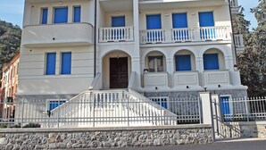 Un edificio a più piani con balconi e una base in pietra.