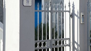 Un cancello con un numero, una base in pietra e un portello in metallo.