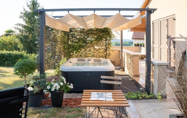 A hot tub under a pergola with a view of a house and garden. - 2 bedroom amazing home in Pazin (Pazin)